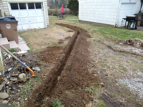 shovel near ditch and garage